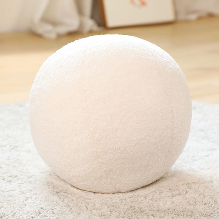 a large white ball sitting on top of a rug