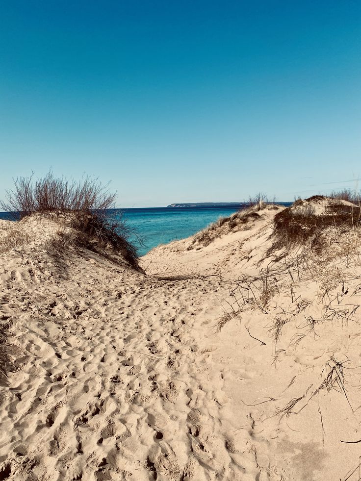 the beach is covered in sand and blue water