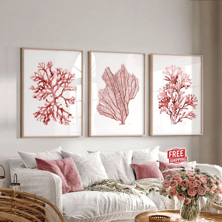 three red coral prints hanging on the wall above a white couch