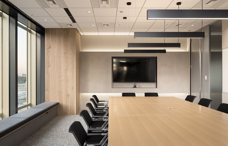 an empty conference room with black chairs and a flat screen tv mounted on the wall