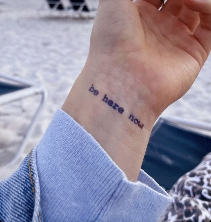 a person with a small tattoo on their wrist saying, do not fear me?