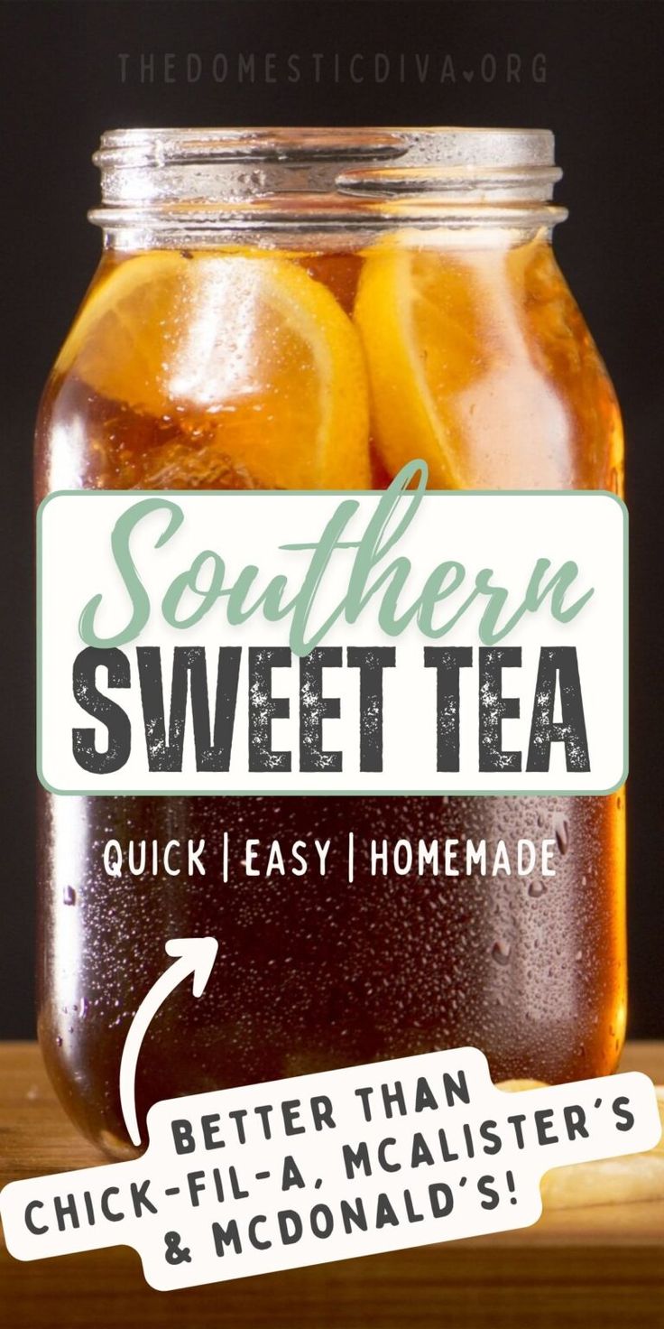 a glass jar filled with tea sitting on top of a wooden table next to lemon slices