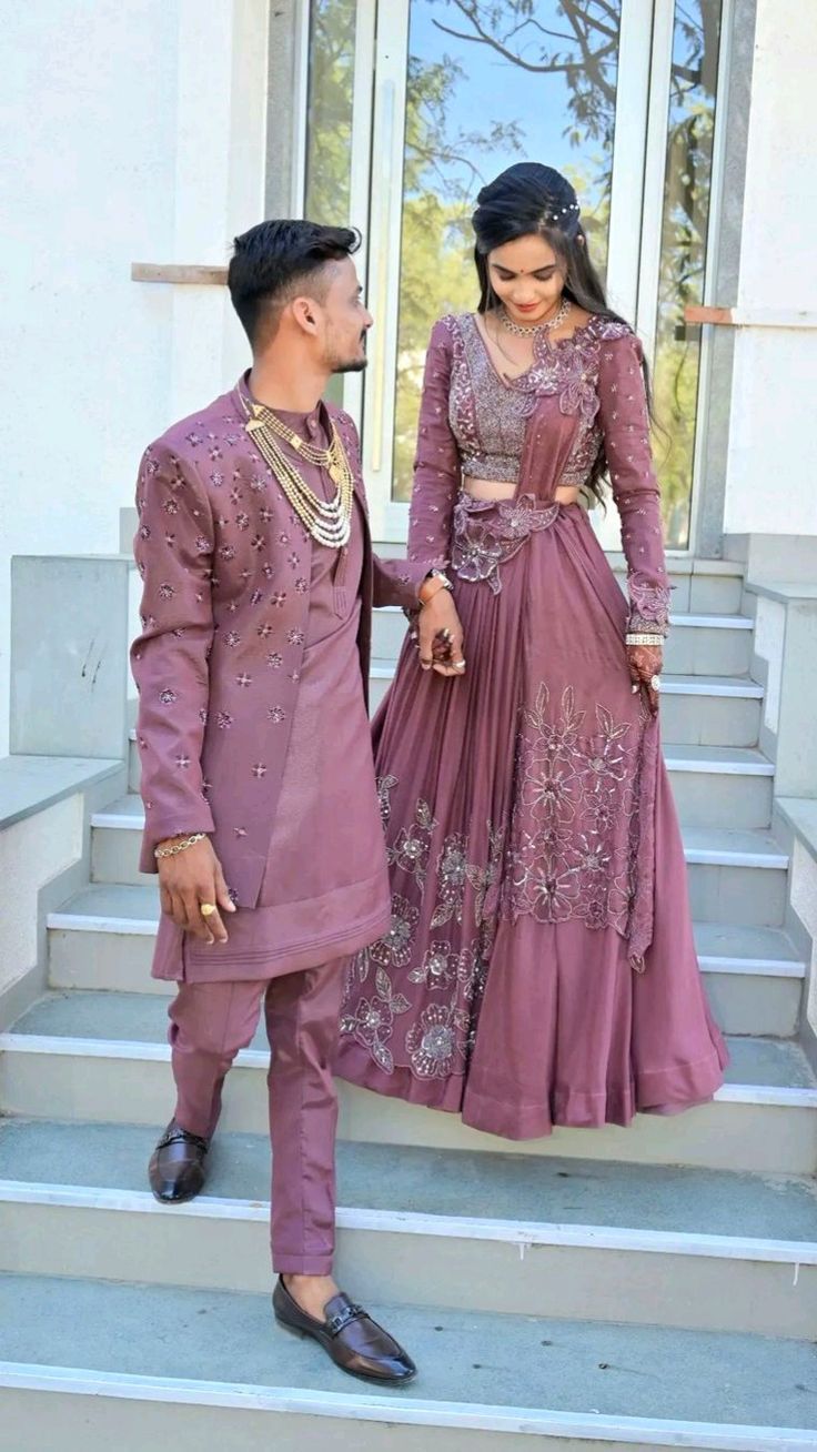 a man and woman in formal wear standing on steps