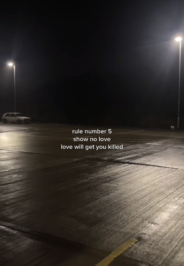 an empty parking lot at night with the words rules number 5 show no love and love will get you killed