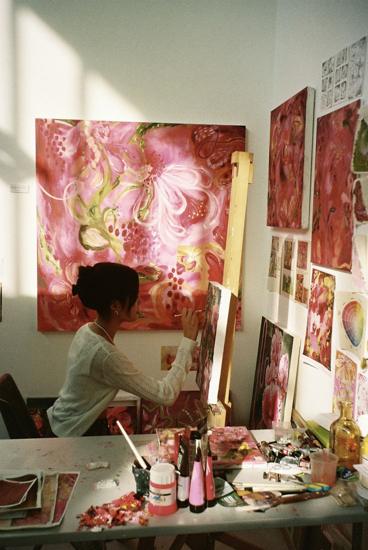 a woman is painting in an art studio