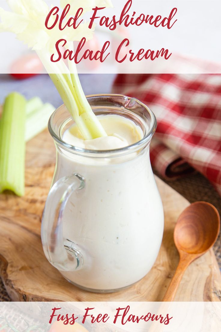 a glass jar filled with white liquid sitting on top of a cutting board next to celery