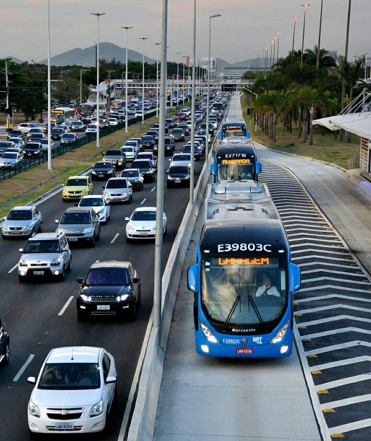 many cars and buses are traveling down the road together in traffic on both sides of the highway