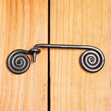 an iron door handle on a wooden door