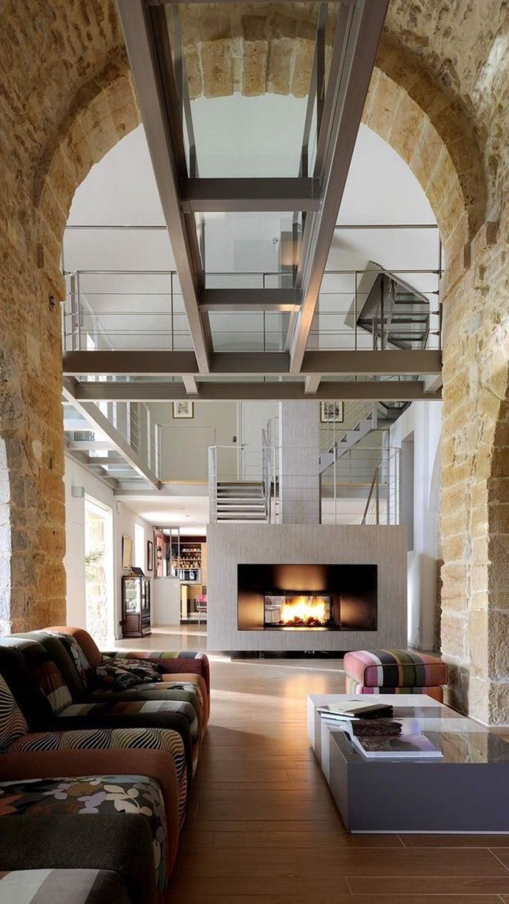 a living room filled with furniture and a fire place in the middle of an archway