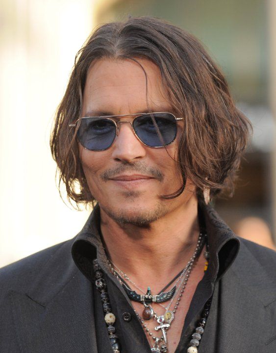 a man with long hair wearing sunglasses and a black shirt