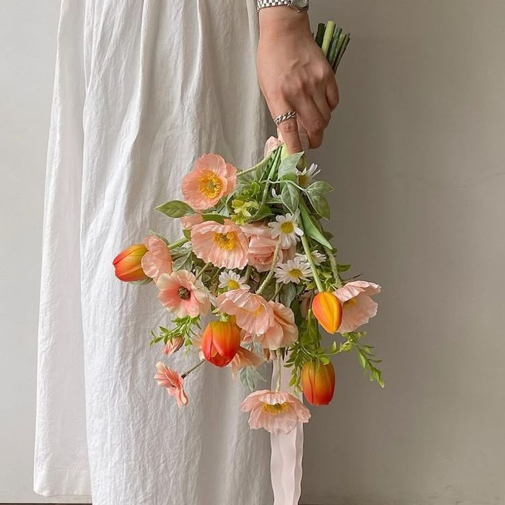 a person holding a bouquet of flowers in their hand