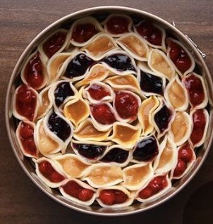 a pan filled with pancakes and toppings on top of a wooden table