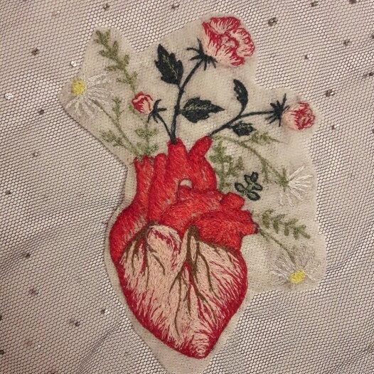 an embroidered heart with flowers on it