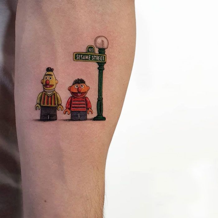 a person with a tattoo on their leg next to a lamp post and street sign