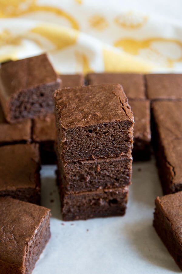 chocolate brownies stacked on top of each other with one slice cut out from it