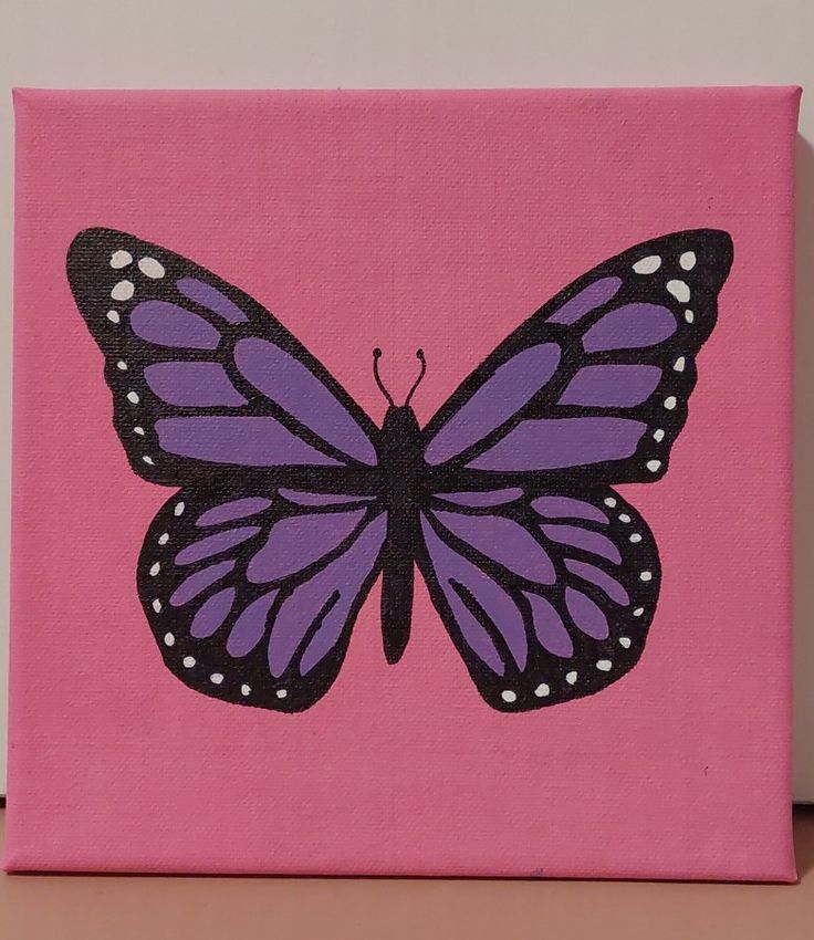 a pink canvas with a purple butterfly painted on it