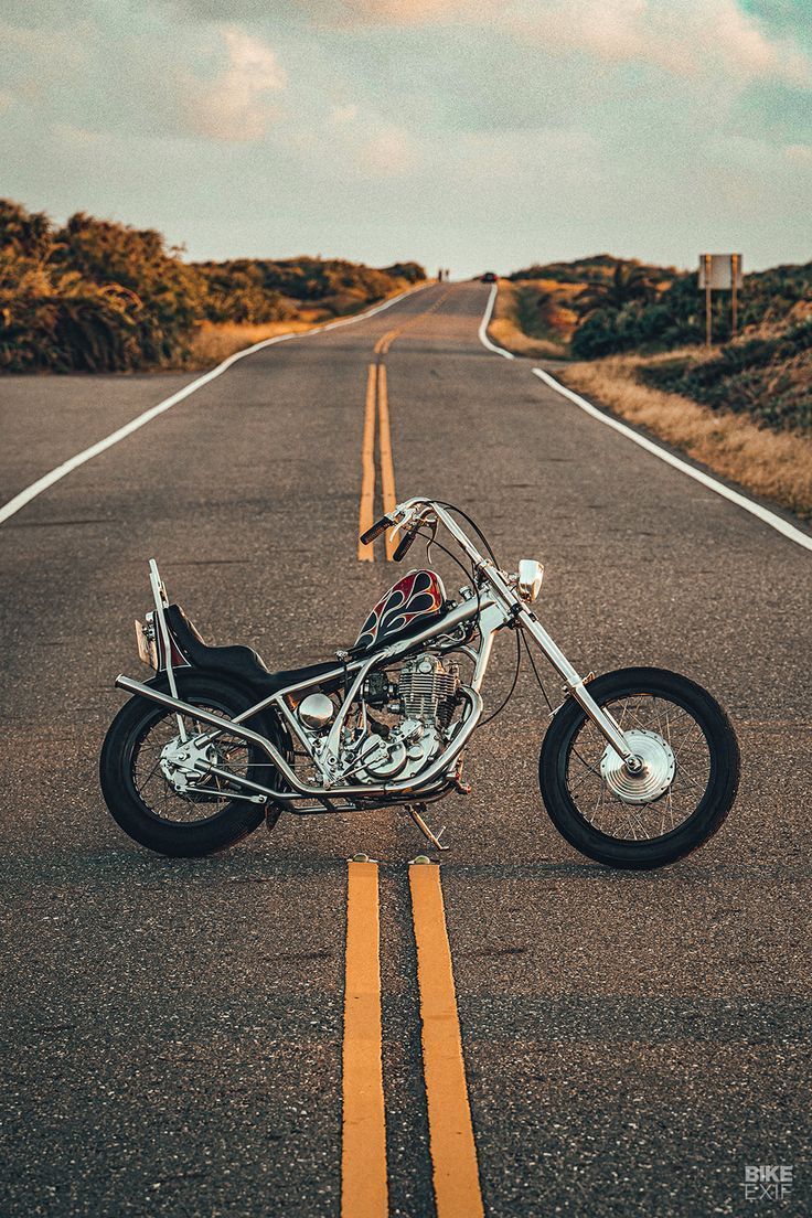 a motorcycle parked on the side of an empty road