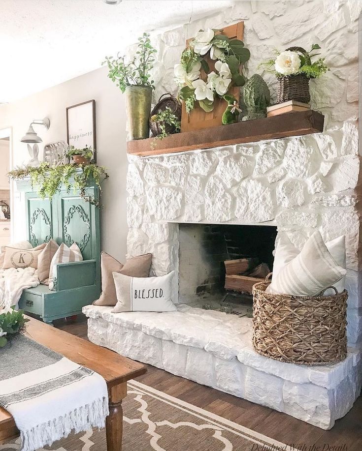 a living room filled with furniture and a fire place covered in plants on top of a mantle