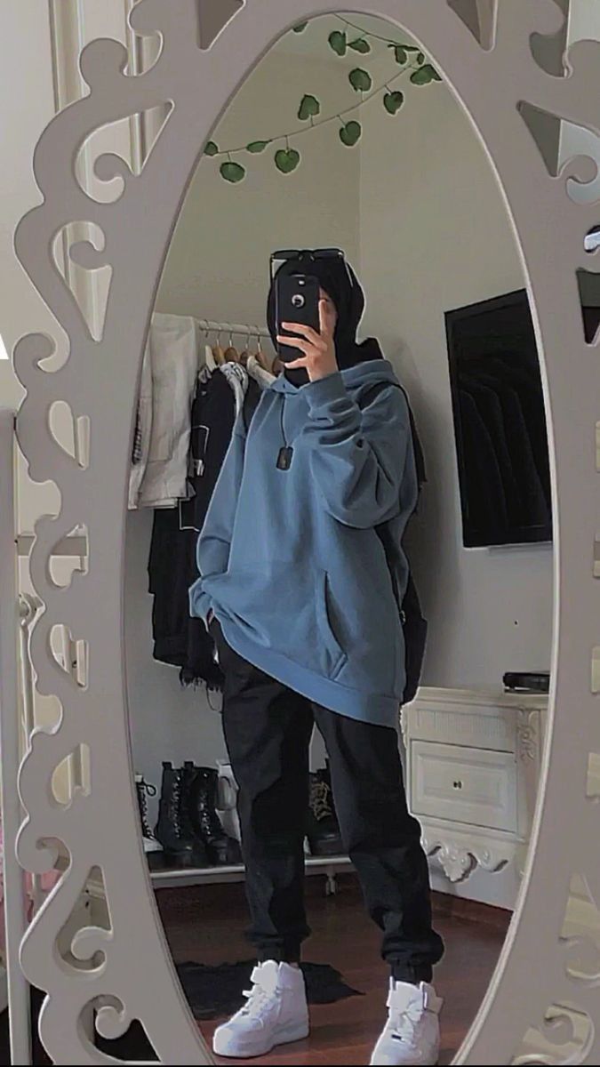 a person taking a selfie in front of a mirror with a hoodie on