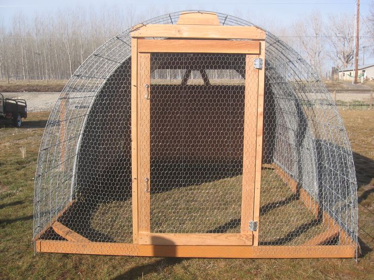 an outdoor chicken coop in the grass