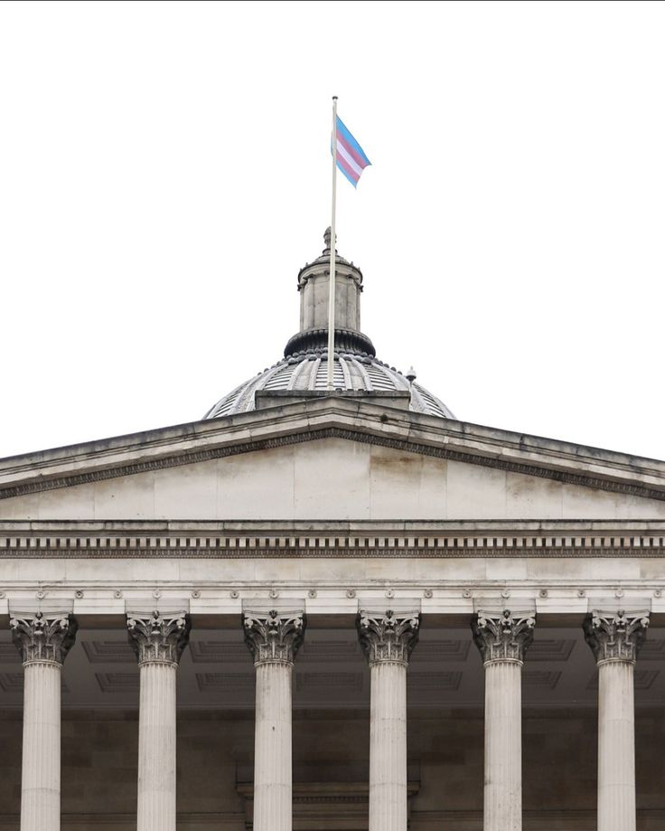 an old building with columns and a flag on top