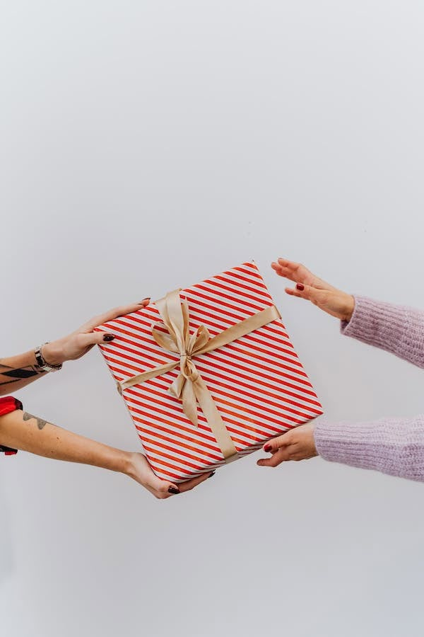 two women holding a wrapped present in their hands