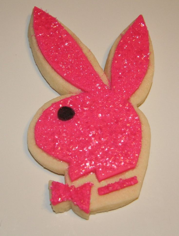 a decorated cookie with pink frosting and a bunny face on it's side