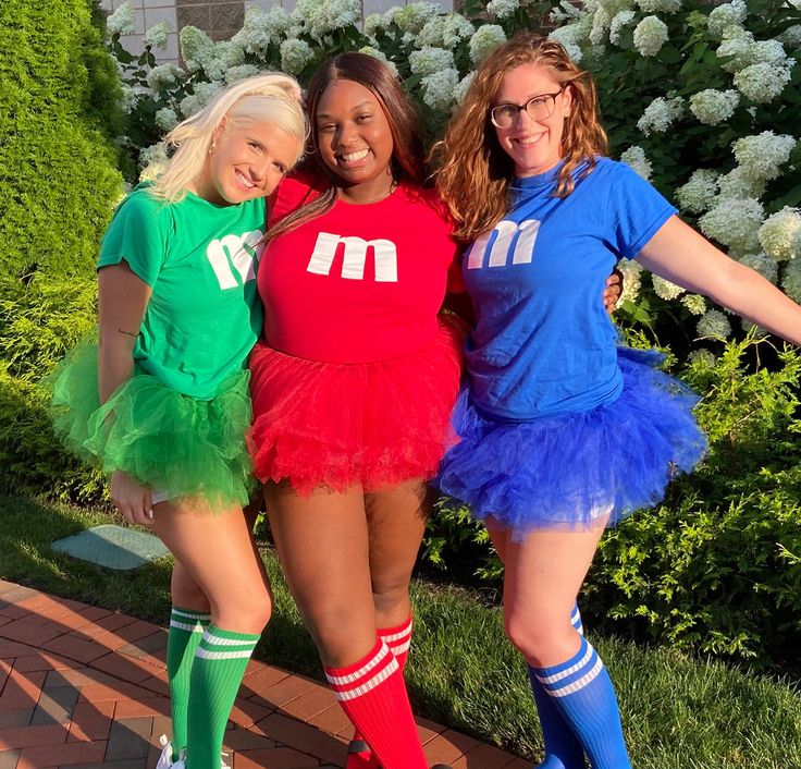 three women in matching outfits posing for the camera