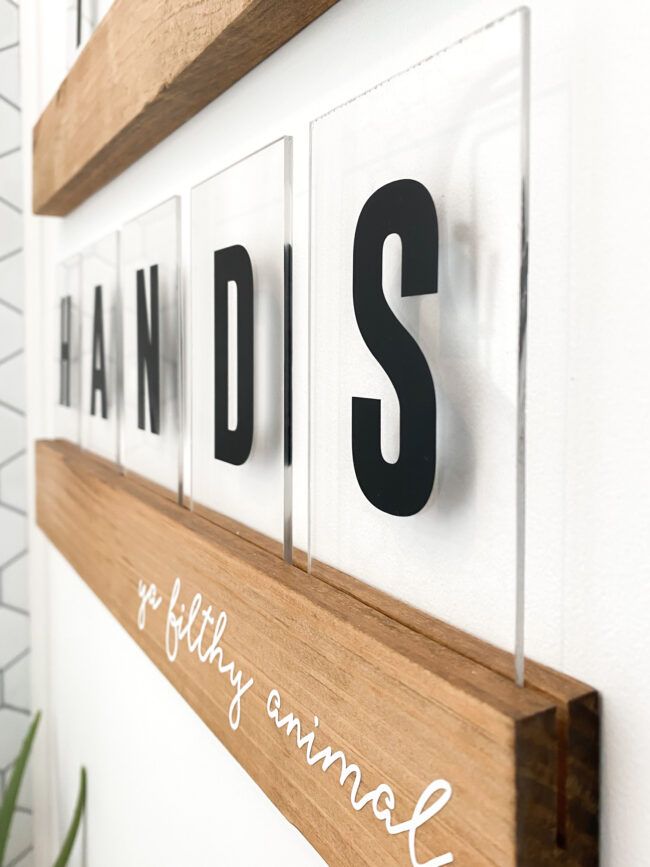 a wooden sign that says diss and is hanging on the wall next to a potted plant