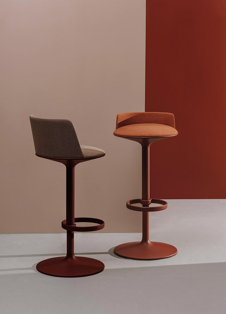 two stools sitting next to each other in front of a red and beige wall