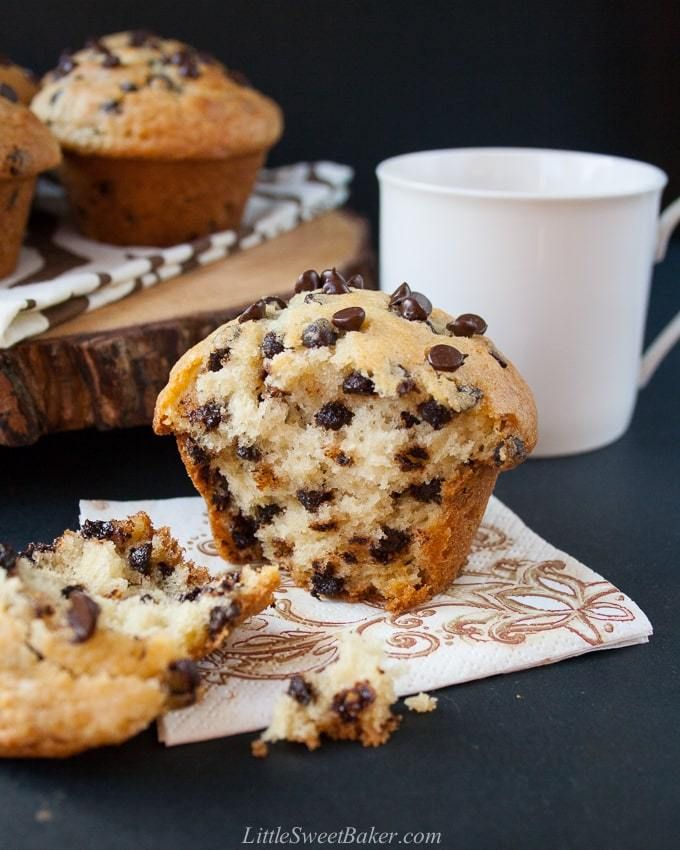 a muffin with chocolate chips on it and a cup of coffee