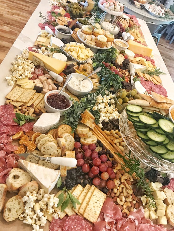 a table filled with lots of different types of foods and cheeses on top of it