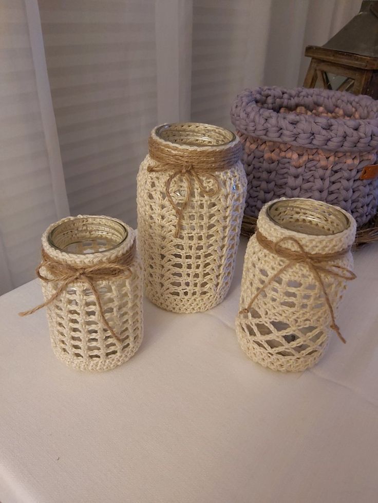 three jars are sitting on a table next to some baskets