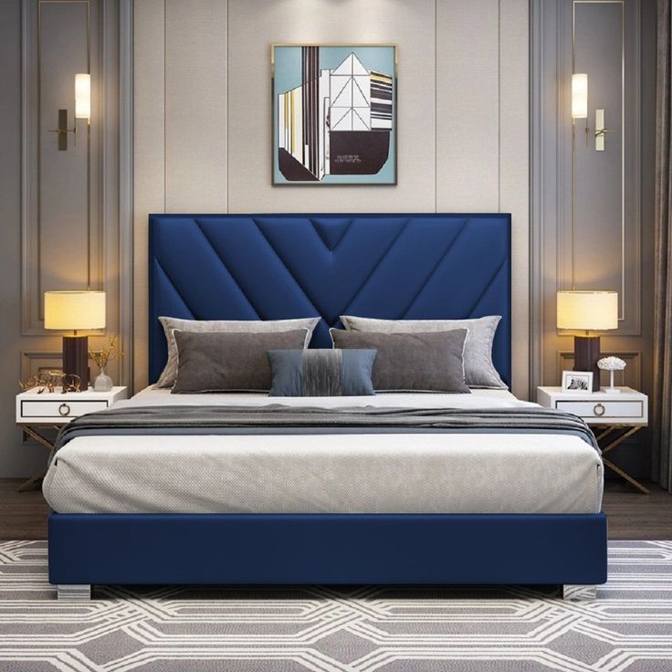 a bed with blue upholstered headboard and two lamps on the side tables