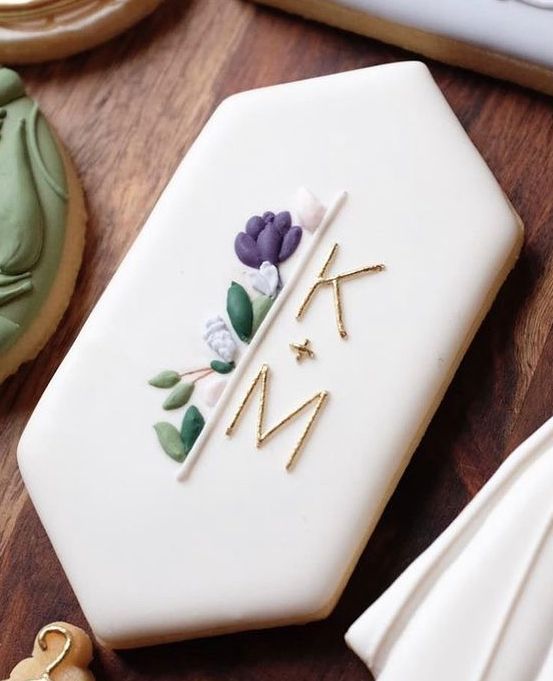 a decorated cookie sitting on top of a wooden table next to cookies and other decorations