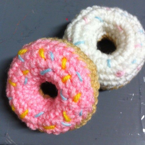 two crocheted doughnuts sitting next to each other