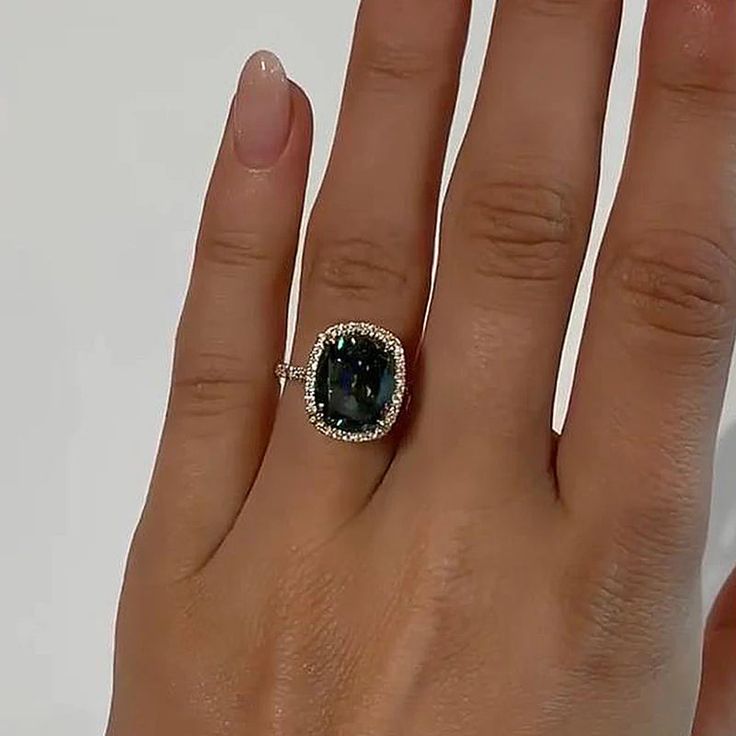 a woman's hand with a ring on it and a blue stone in the middle