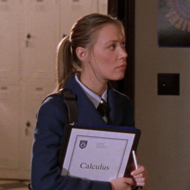 a woman holding a clipboard in her hand and looking at the wall behind her