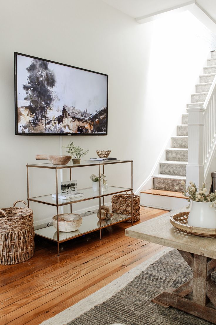 a living room filled with furniture and a painting on the wall over a coffee table