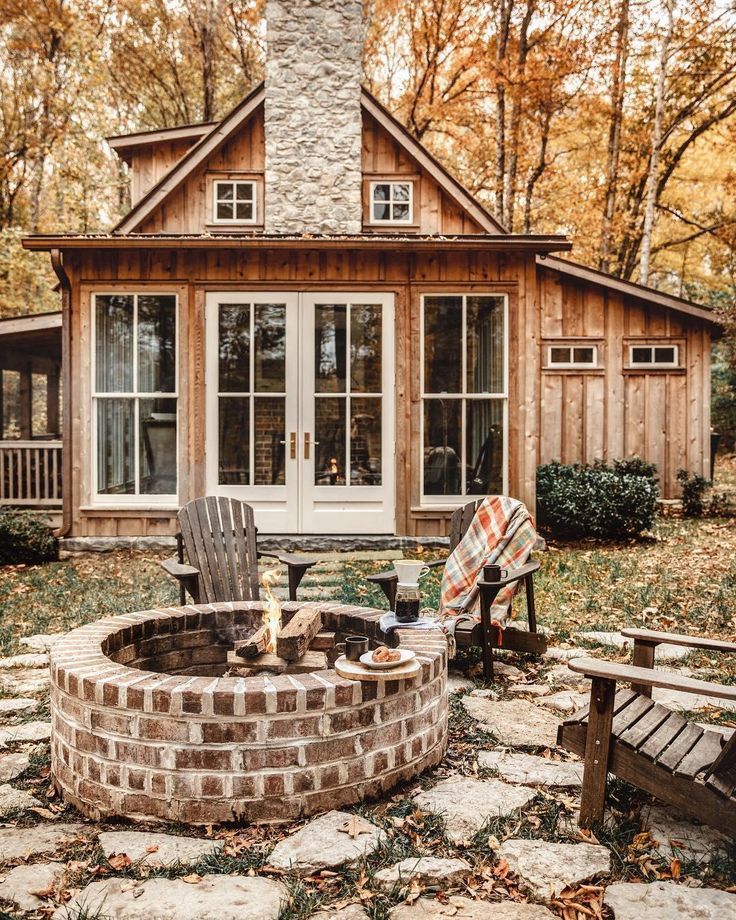 a fire pit sitting in front of a wooden house