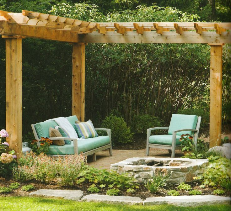 an outdoor seating area with two chairs and a fire pit in the middle of it