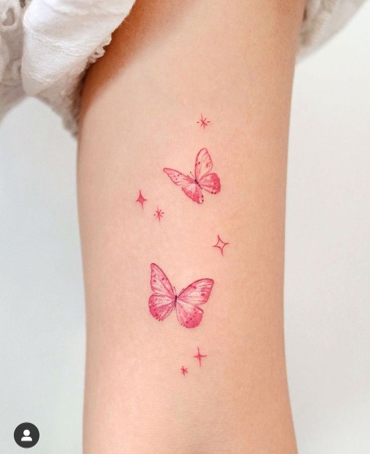 two pink butterflies on the back of a woman's right leg, with stars all over them