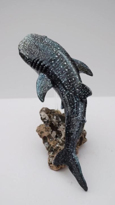 a figurine of a whale on a rock