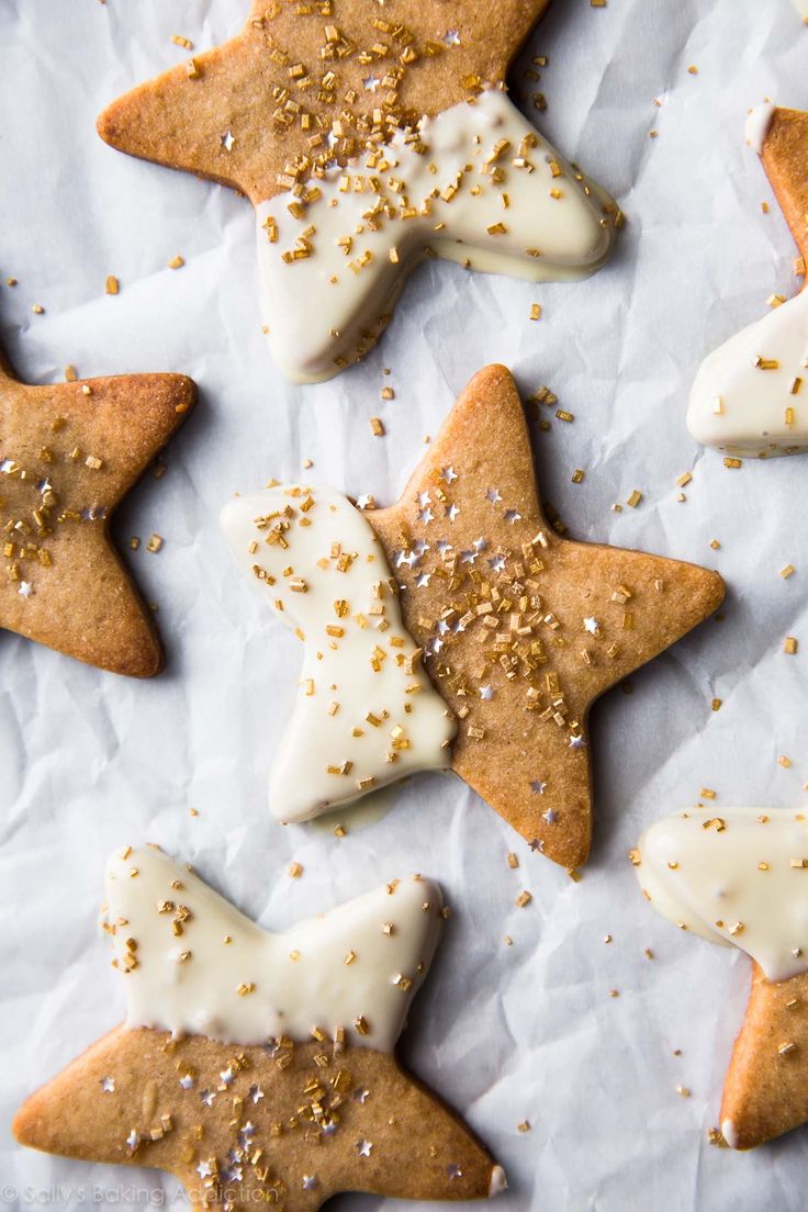 several star shaped cookies with white icing and sprinkles on paper towel