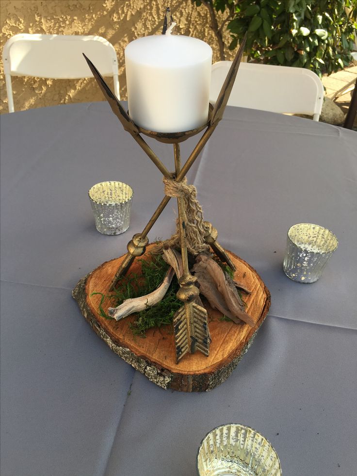 a candle holder made out of wood and branches on top of a blue table cloth