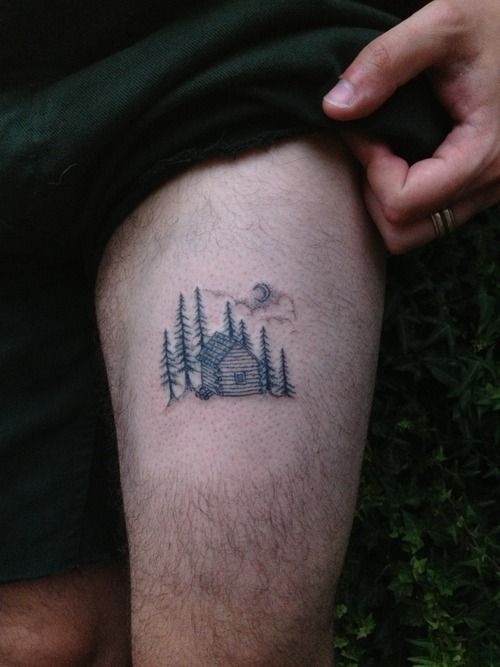 a man with a tattoo on his leg that has trees and a house in it