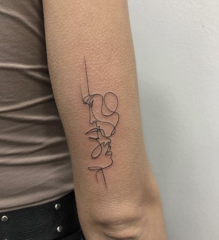 a woman's arm with a line drawing tattoo on the left side of her arm