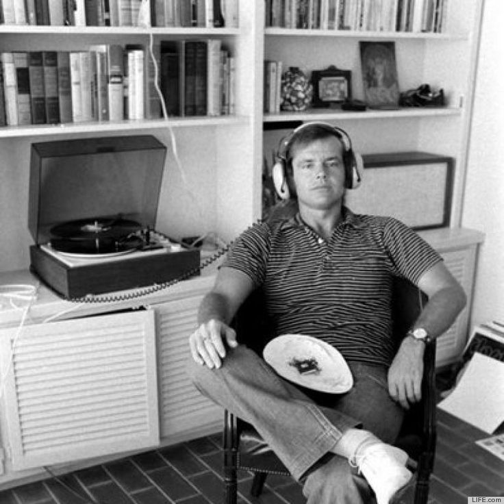 a man sitting in a chair with a plate on his lap and headphones to his ears