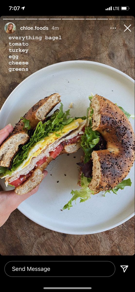 a person is holding a sandwich on a plate