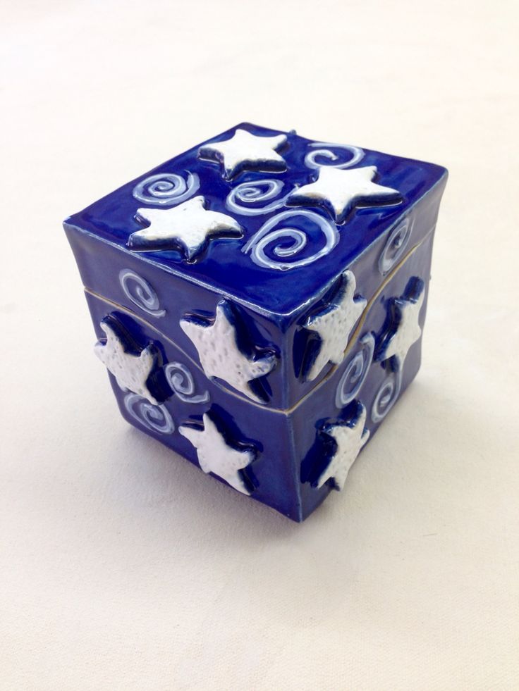 a blue and white ceramic object with stars on it's sides sitting on a table